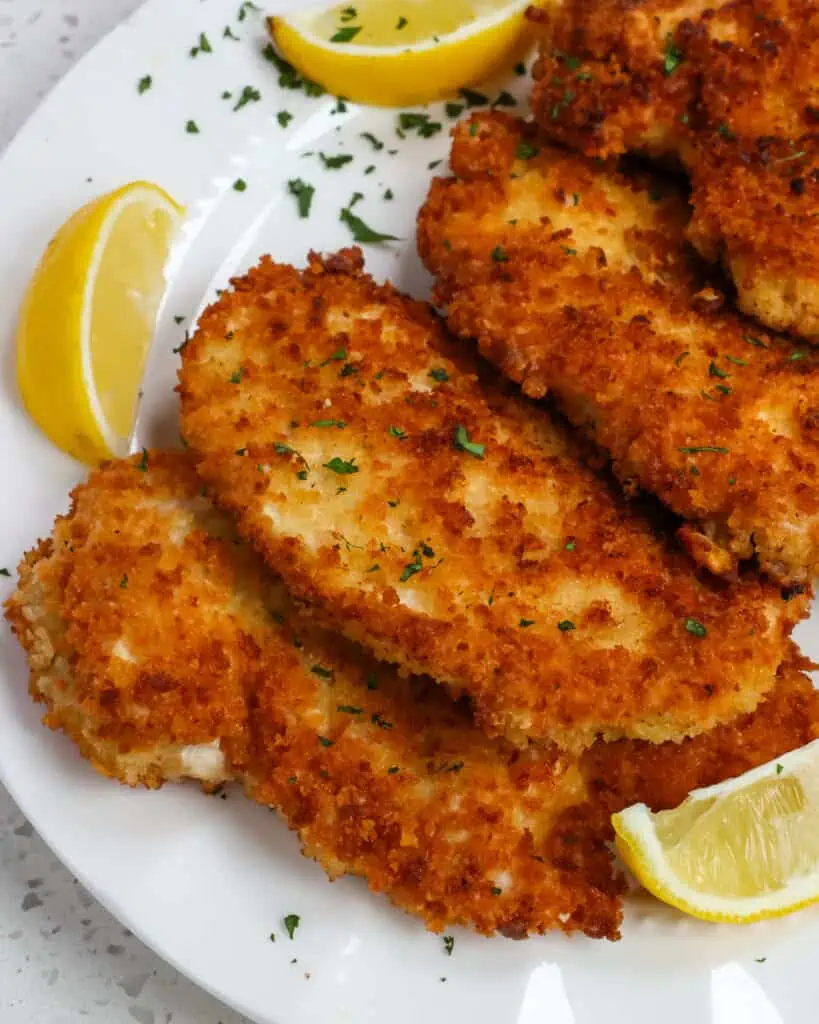 Crispy Chicken Schnitzel are breaded chicken cutlets that are pan fried to golden crispiness and served with a spritz of lemon and chopped fresh parsley or dill.
