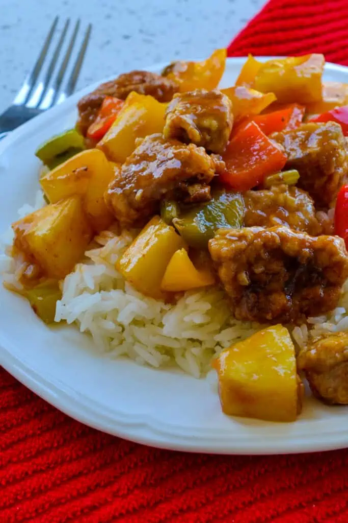 Crispy breaded pan fried pork tenderloin bites served over white rice with tender green and red peppers and pineapple