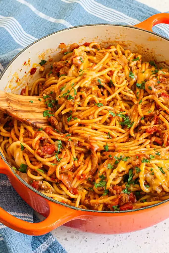 The taco spaghett dish is topped with a healthy amount of cheddar cheese, Monterey Jack Cheese, and chopped fresh cilantro.