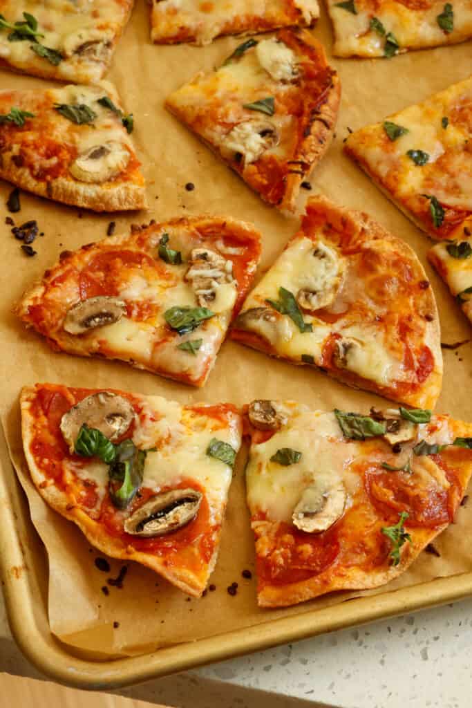 Add another layer of mozzarella and bake for 5-7 minutes or until the cheese is melted and lightly browned and the tortilla is crispy on the edges. Sprinkle the cooked pizza with chopped fresh basil. 