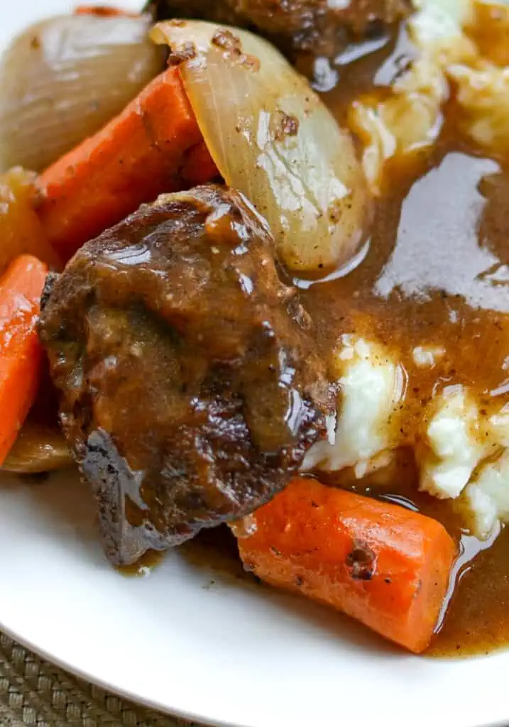 These slow cooked Beef Short Ribs are perfectly seasoned beef short ribs, carrots and onions in a tasty broth that cooks into a amazing gravy.