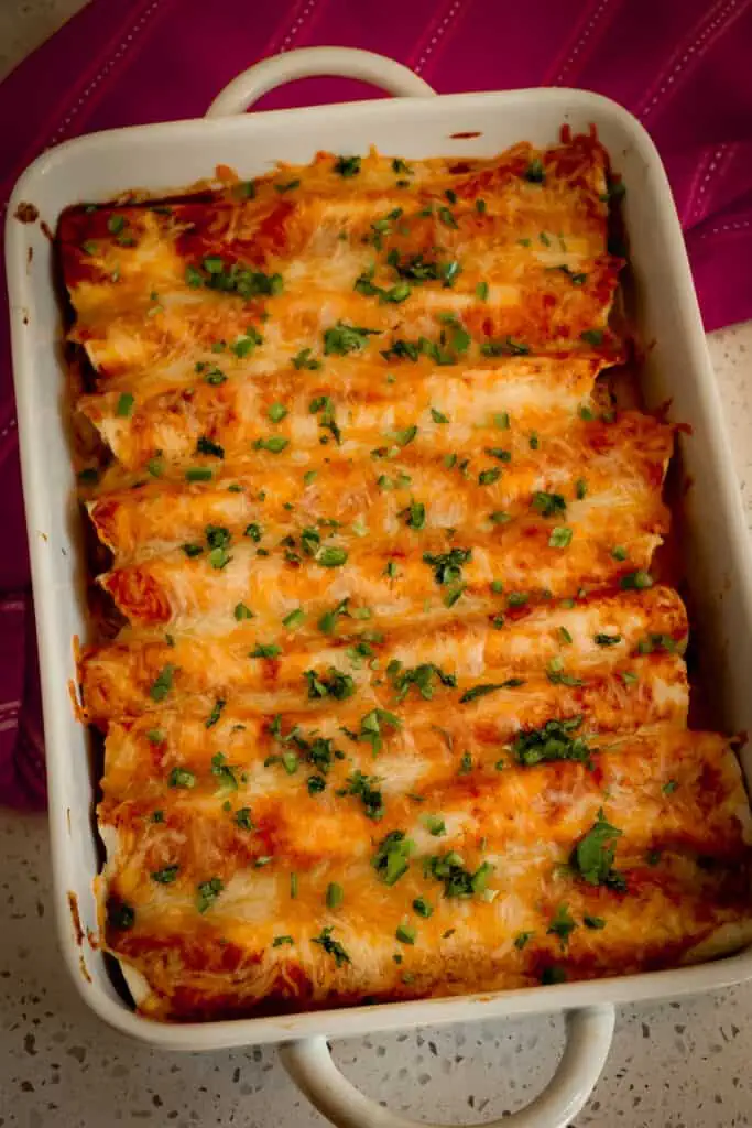 This Chicken Enchilada recipe is a true flavor explosion with green chilis, homemade enchiladas sauce, and a Mexican cheese blend. No dull bland flavors here.