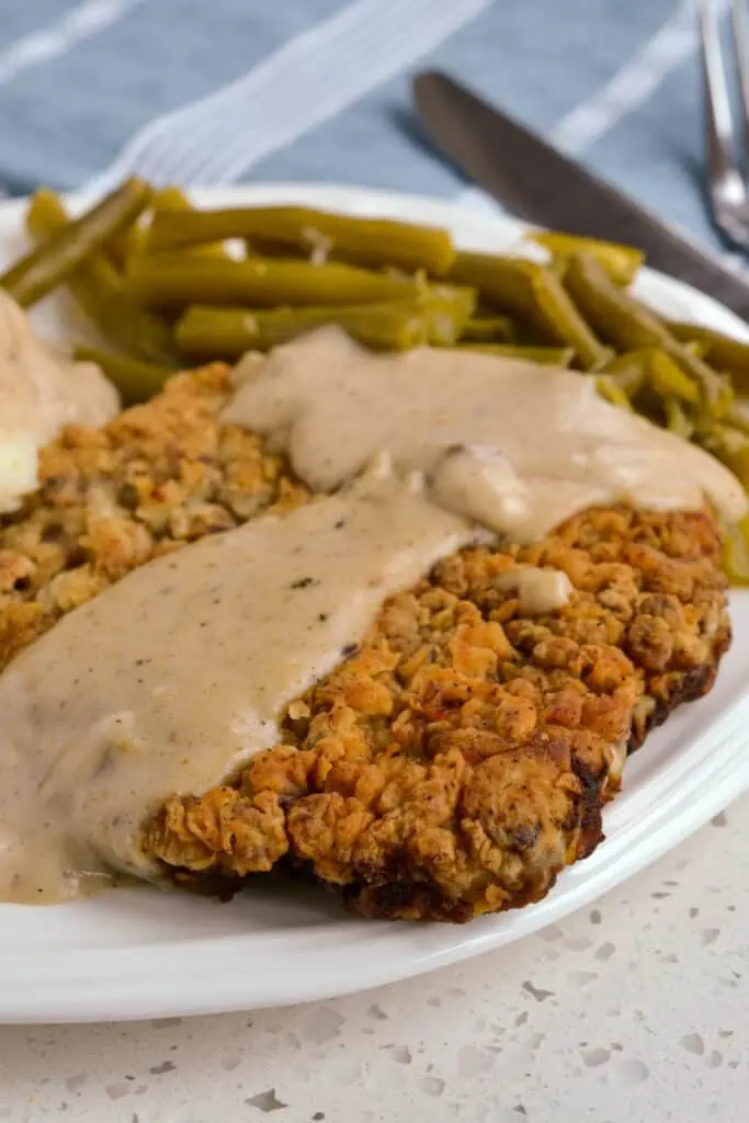 This Chicken-Fried Steak is a delectable southern classic with tender cube steak double breaded, fried to golden perfection, and smothered in creamy flour and milk-based gravy made from the pan drippings.