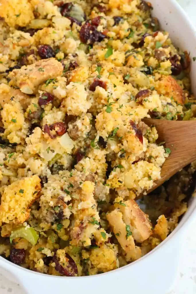 A Southern Cornbread Dressing Recipe made with homemade cornbread, French bread, ground sausage, and dried cranberries with fresh herbs like rosemary, thyme, and sage.