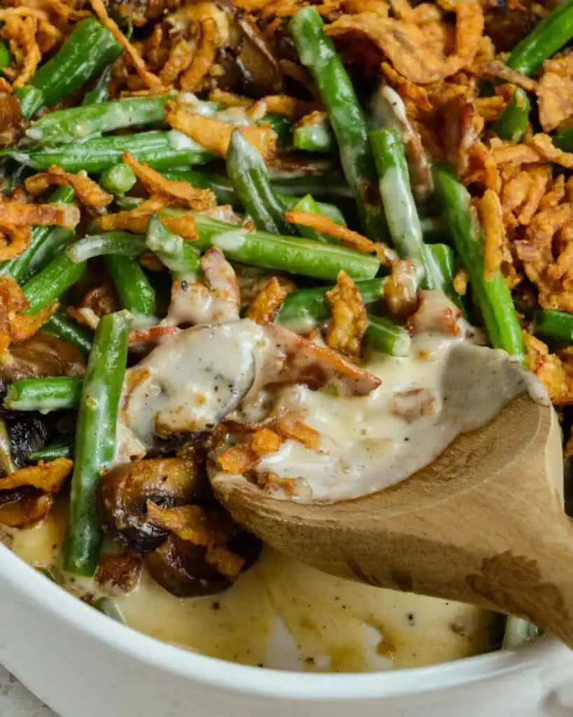 This scrumptious made from scratch Green Bean Casserole combines tender green beans, bacon, mushrooms, and garlic with a creamy lightly seasoned sauce all topped with crispy fried onions.