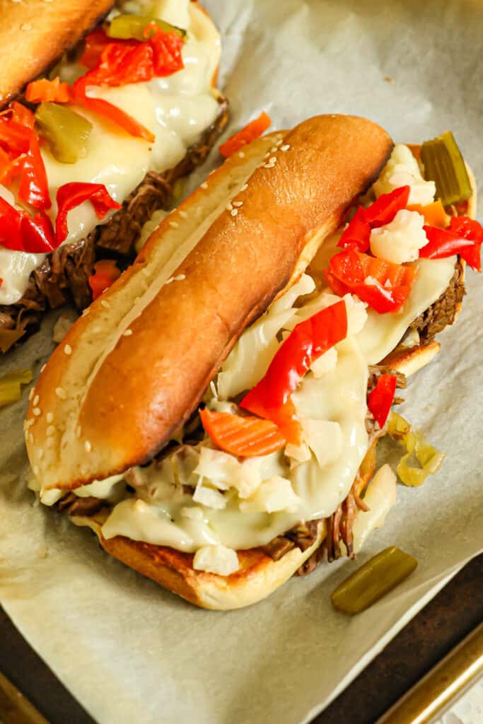 This mouthwatering melt-in-your-mouth Italian Beef cooks up easily in the crock pot with beef broth, Italian dressing mix, and pepperoncini and is always a huge hit.  Make it up into hot sandwiches with melty cheese and pickled vegetables, or serve over mashed potatoes for the ultimate comfort meal.