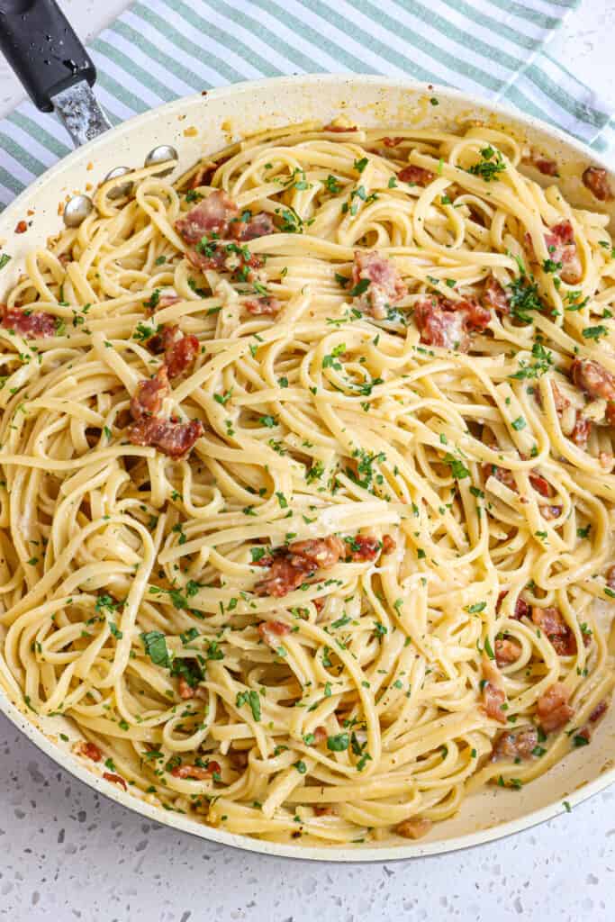 A quick and easy Pasta Carbonara recipe made with crisp bacon and sweet garlic in a simple creamy Parmesan Sauce.  It is the ultimate Italian comfort dish recipe and one everyone should try. 