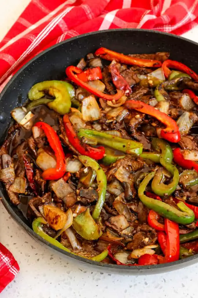 This Szechuan Beef stir fry combines mouthwatering marinated flank steak with tender-crisp bell peppers, onions, garlic, and ginger in a spicy and savory sauce seasoned with Szechuan peppercorns and a little bit of brown sugar to mellow the heat.