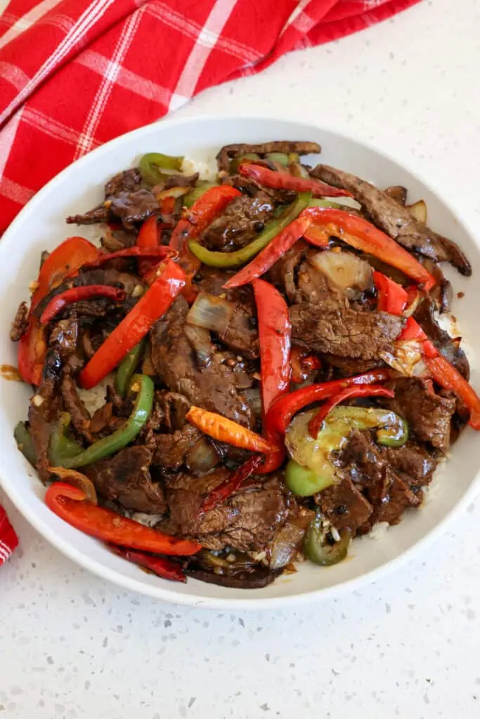 Tasty Szechuan Beef is tender thin slices of marinated beef seared and served with stir fried bell peppers and onions, all coated with a mouthwatering spicy and savory sauce with Szechuan Peppers.