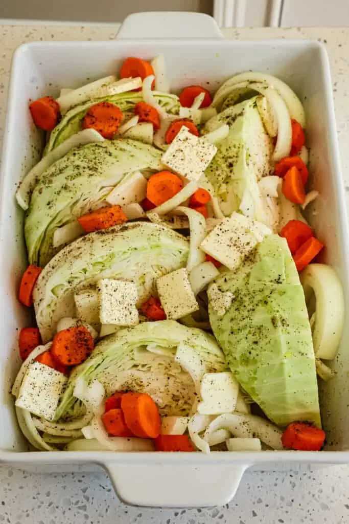 Drizzle the dish with chicken broth and season with a healthy amount of kosher salt and freshly ground black pepper. Scatter the pats of butter over the veggies.