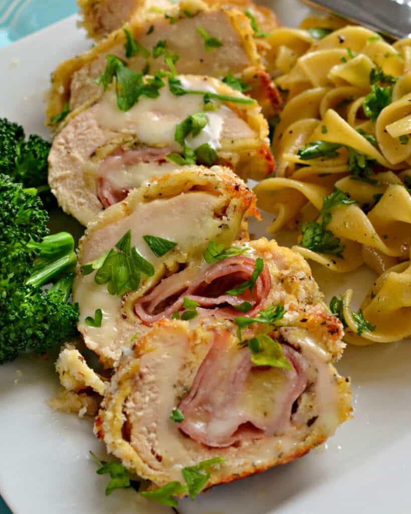 This classic baked Chicken Cordon Bleu Recipe is crispy breaded chicken breasts stuffed with ham and Swiss cheese and drizzled with a mustard Parmesan cream sauce. 