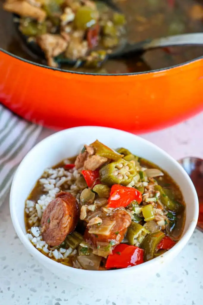 Gumbo is a hearty stew or thick soup with rich flavors from a dark chocolate roux, chicken, sausage, and sometimes seafood like shrimp or crab, fresh vegetables like onions, bell peppers, and okra, and, of course, Cajun seasonings.