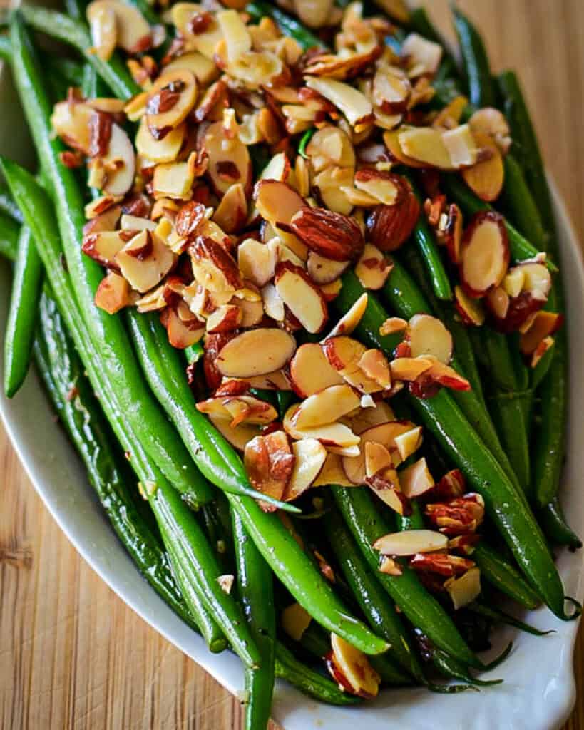 An overhead view of green beans almondine in a serving dish.