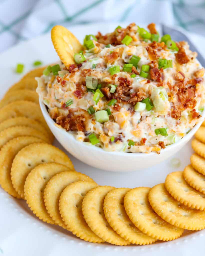 Million Dollar Dip on a white platter served with buttery crackers. 