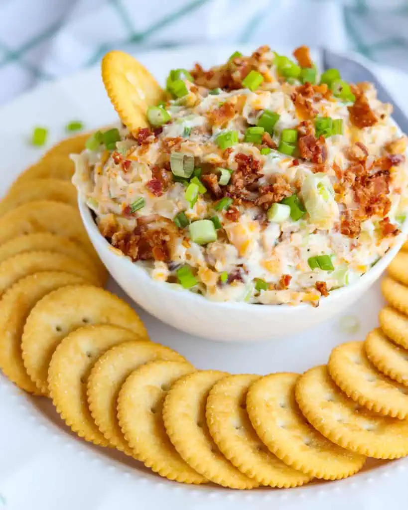 Million Dollar Dip on a white platter served with buttery crackers. 