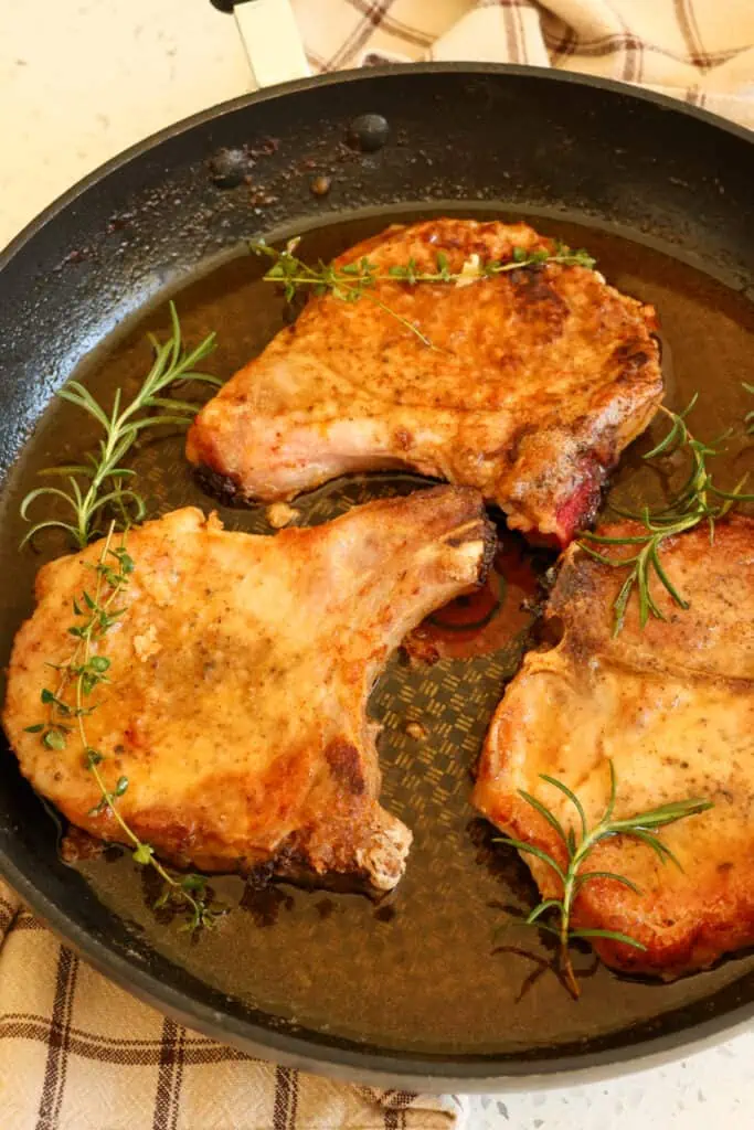 Pan Fried Pork Chops are seasoned and breaded pork chops fried in butter and served with sweet and tangy pan juices.