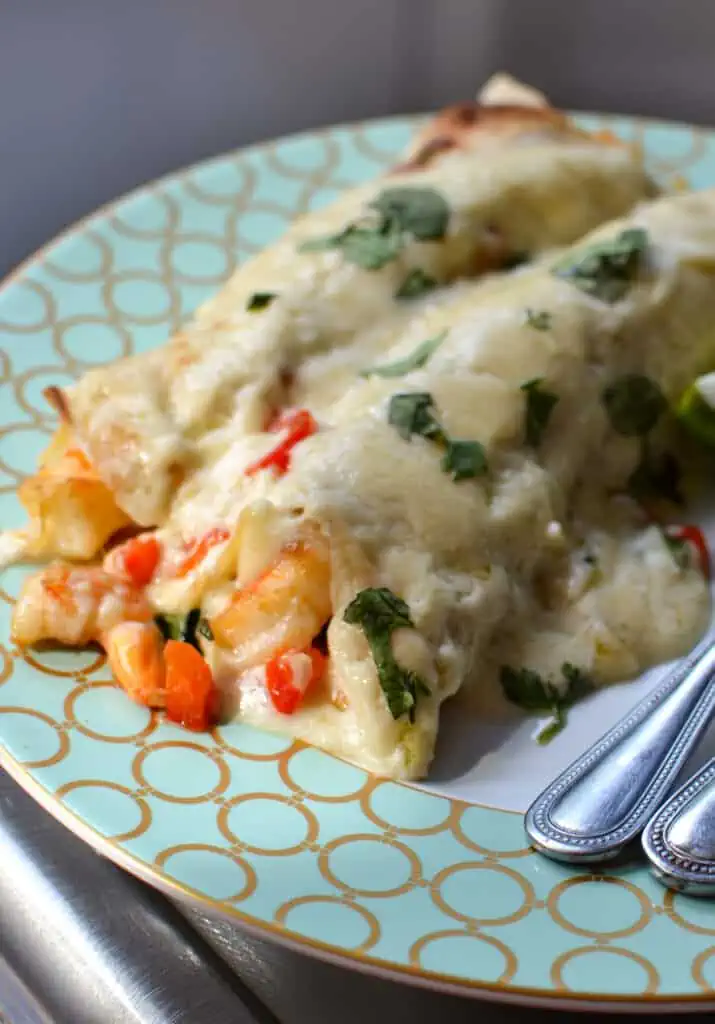Creamy Shrimp Enchiladas bring together fresh shrimp, onions, red bell pepper, and garlic all wrapped up in a creamy Monterrey Jack cheese sauce.