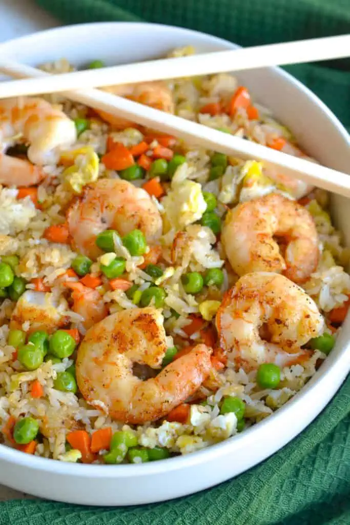 This easy Shrimp Fried Rice is lightly seasoned with ginger and garlic and full of carrots, peas, green onions, and fresh shrimp. Make this delicious, better-than-takeout fried rice at home for a simple and delicious dinner!