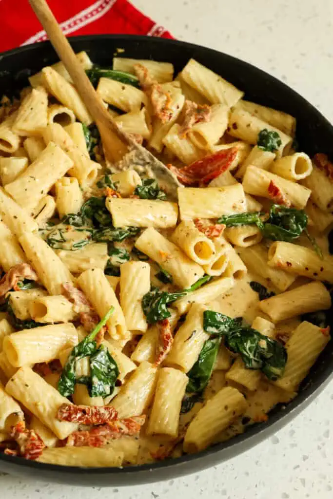 Quick and easy Sun-Dried Tomato Pasta with spinach and garlic in a mouth-watering creamy parmesan cheese sauce.