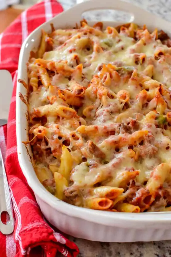 A super easy family friendly classic casserole with mostaccioli, Italian Sausage, peppers, onions, marinara and mozzarella. 