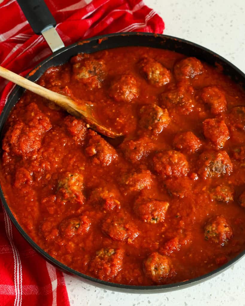 A large skillet full of meatballs and marinara.