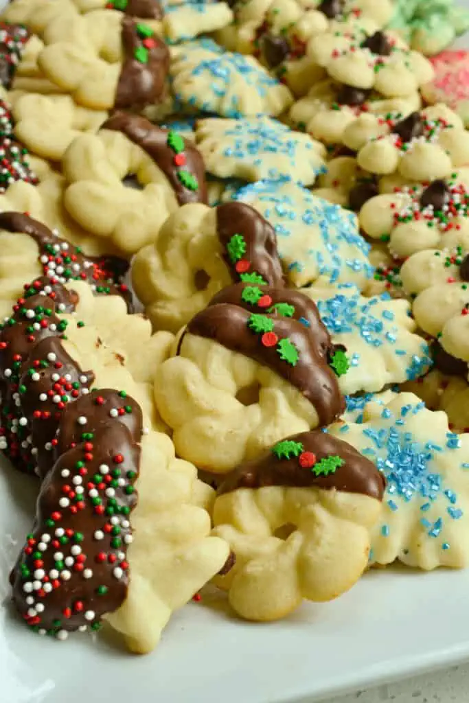 These petite buttery Spritz Cookies are the perfect holiday treat.  They are delicious, quick, easy and so fun to decorate. Add these adorable treats to your Christmas cookie tray. 