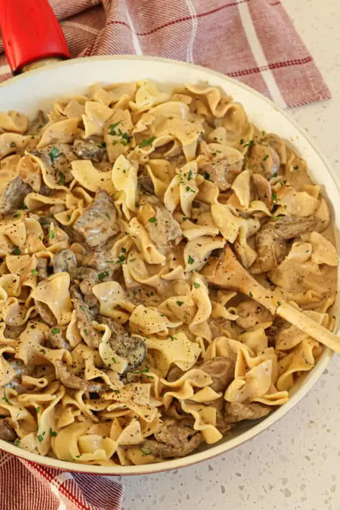 This easy Beef Stroganoff recipe is a mixture of tender seared beef, sweet onions, mushrooms, and fresh minced garlic in a creamy stroganoff sauce that has been lightly seasoned with parsley.  It is traditionally served with egg noodles; however, it is equally delicious over mashed potatoes or rice.