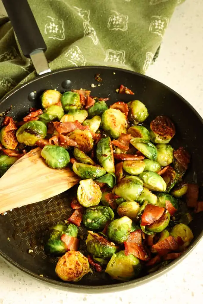 Add the cooked chopped bacon back to the skillet. Season with salt and pepper to taste. Drizzle with maple syrup and toss to coat. 