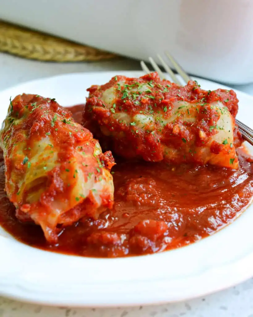 Family-friendly Cabbage Rolls stuffed with ground pork, ground beef, and rice smothered in a sweet and tangy tomato sauce.