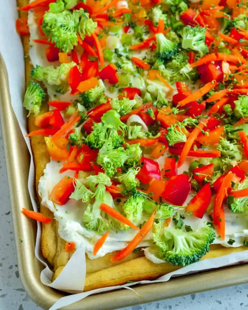 This cold Veggie Pizza Recipe made with ranch cream cheese is one of our favorite spring and summer party appetizers with fresh garden vegetables like carrots, broccoli, bell peppers, and green onions. 