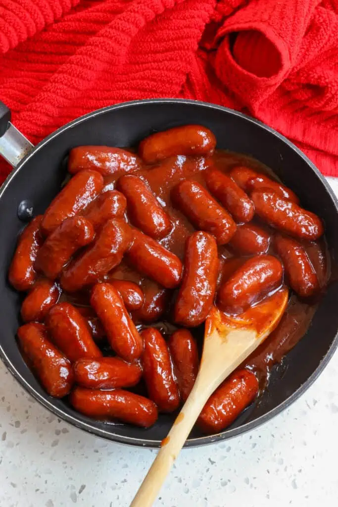 This little Smokies Recipe with little smoked sausages in a slightly spicy barbecue glaze are easily made in the crock pot, stovetop or oven. 