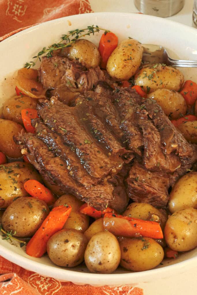 Tender, flavorful, slow-cooked chuck roast, carrots, potatoes, and onions smothered with a rich beef gravy that is perfectly seasoned all in a large serving bowl. 