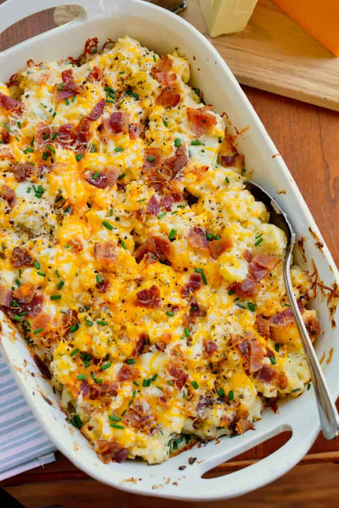Keto-friendly loaded Cauliflower Casserole combines steamed cauliflower, cream cheese, sour cream, sharp cheddar, Monterey Jack, bacon, and chives.