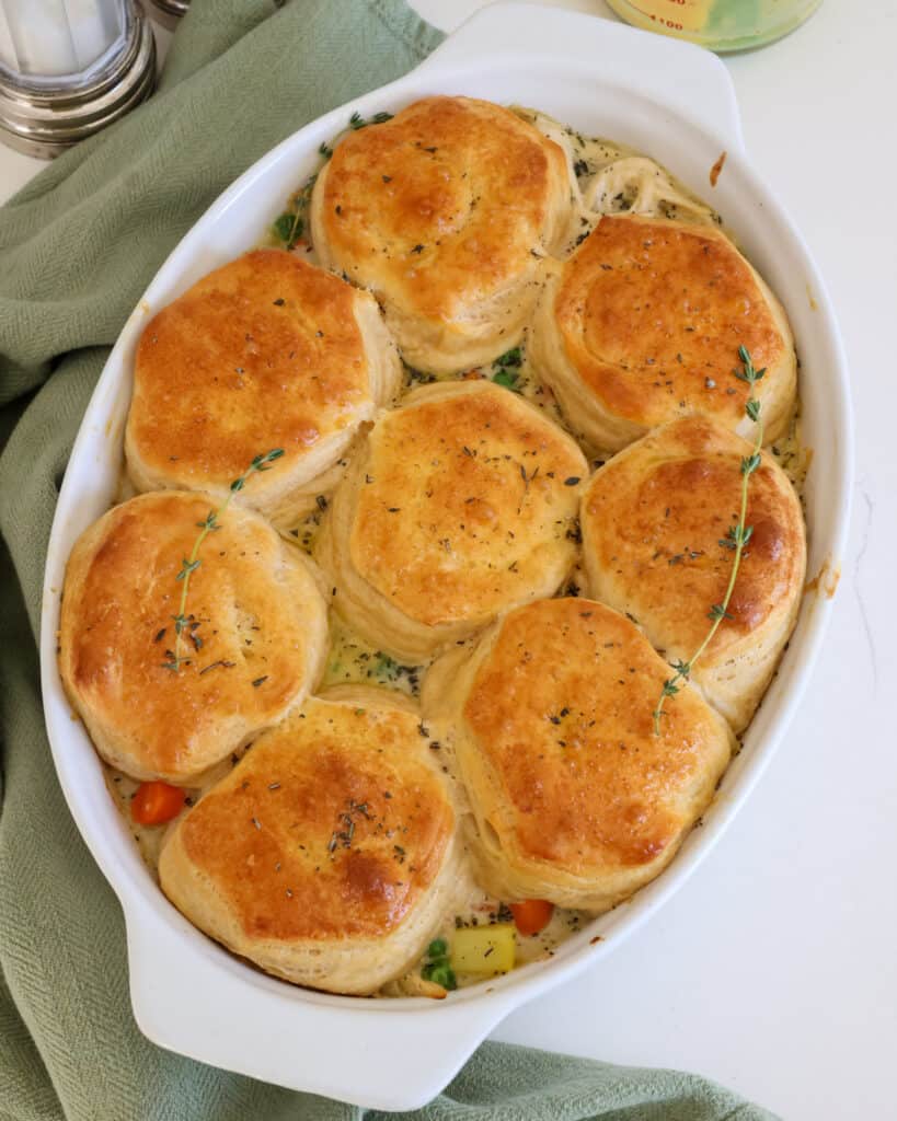 This comforting chicken pot pie casserole features a creamy chicken and vegetable filling topped with buttery and flaky biscuits.