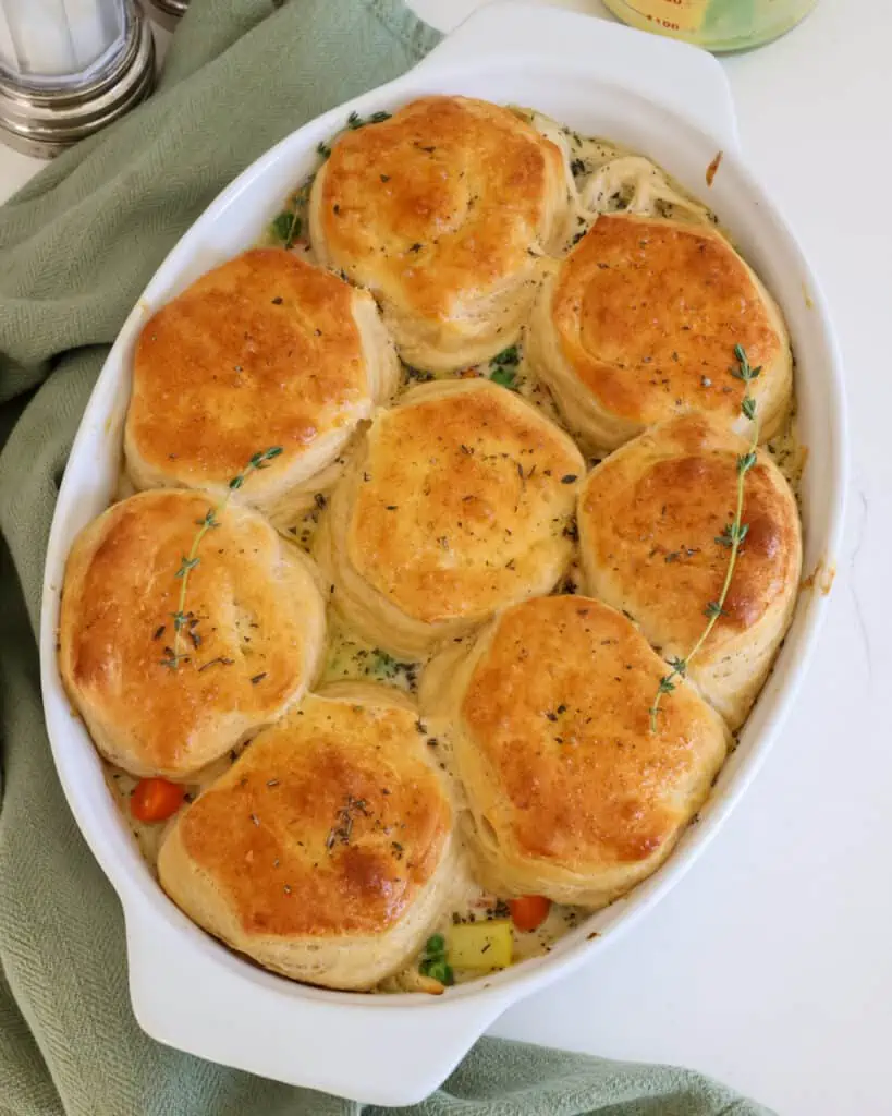 This comforting chicken pot pie casserole features a creamy chicken and vegetable filling topped with buttery and flaky biscuits. 