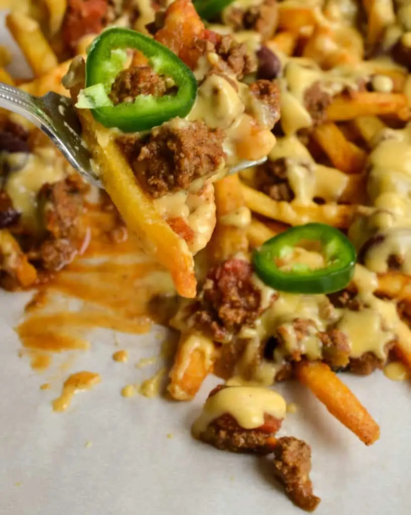 Easy Chili Cheese Fries made with crispy fries, thick hearty chili, and an easy to make creamy sharp cheddar cheese sauce. They are the perfect main dish or party appetizer. 