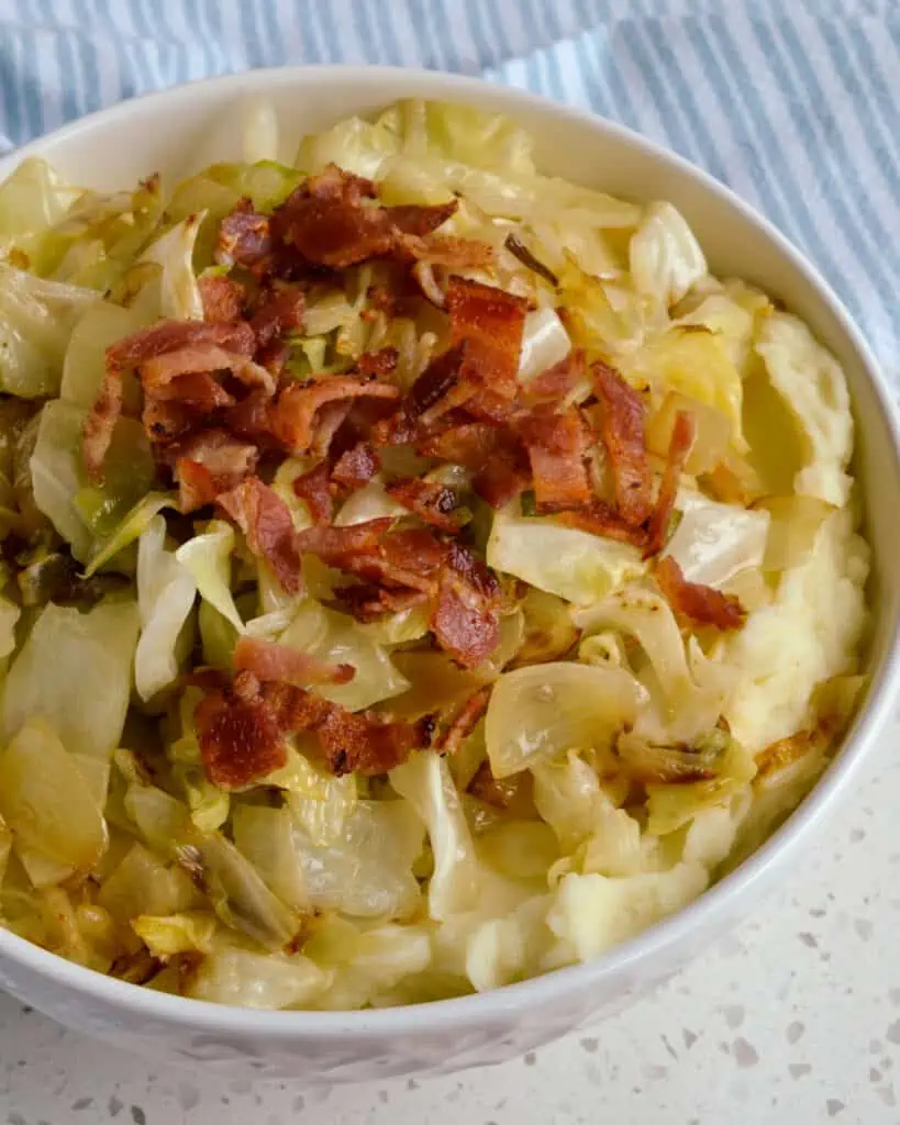 Irish Colcannon is made with mashed potatoes, fried cabbage, onions, crisp bacon and seasoned with salt and pepper.