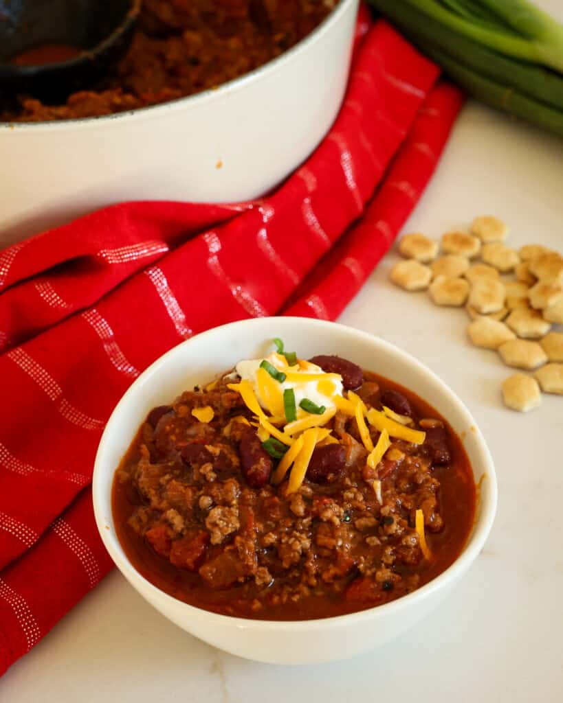 Garnish the chili with cheddar cheese, sour cream, and green onions.