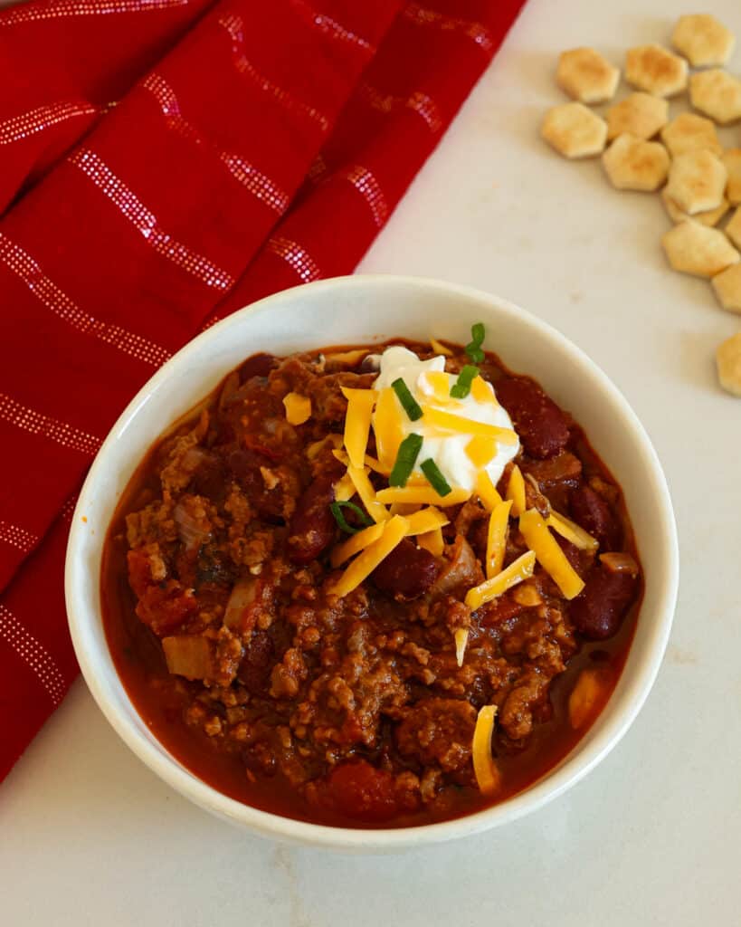 Homemade Chili is a thick ground beef and kidney bean chili in a tomato base with the perfect balance of spice from chili powder, ground cumin, smoked paprika, black pepper, and ground cayenne pepper.