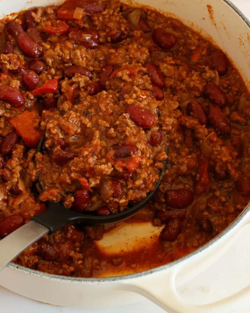 This homemade Chili is a thick ground beef and kidney bean chili in a tomato base with the perfect balance of spices. Enjoy this tasty chili in a bowl with cheese, sour cream, green onions, and cheddar.