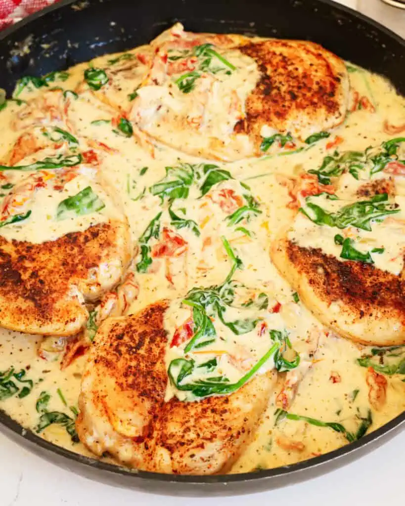 A close up view of Tuscan Chicken in a large black skillet.
