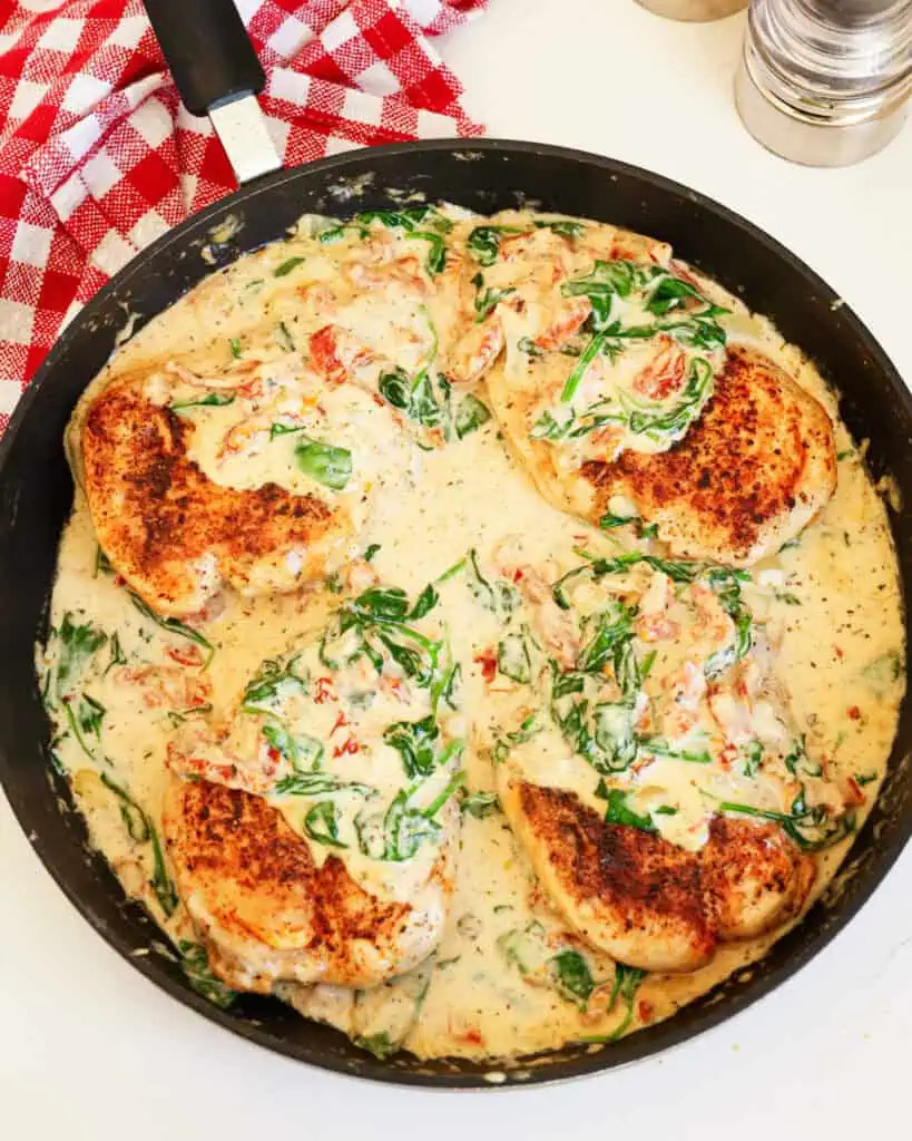 Tuscan Chicken An overhead view of Creamy Tuscan Chicken in a black skillet.