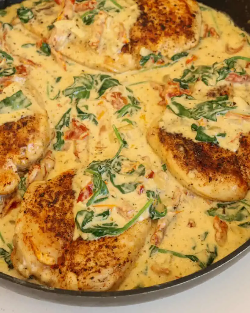 Creamy Tuscan Chicken combines golden brown chicken breasts, spinach, and sun-dried tomatoes in an Italian seasoned rich and creamy garlic Parmesan Cheese sauce.