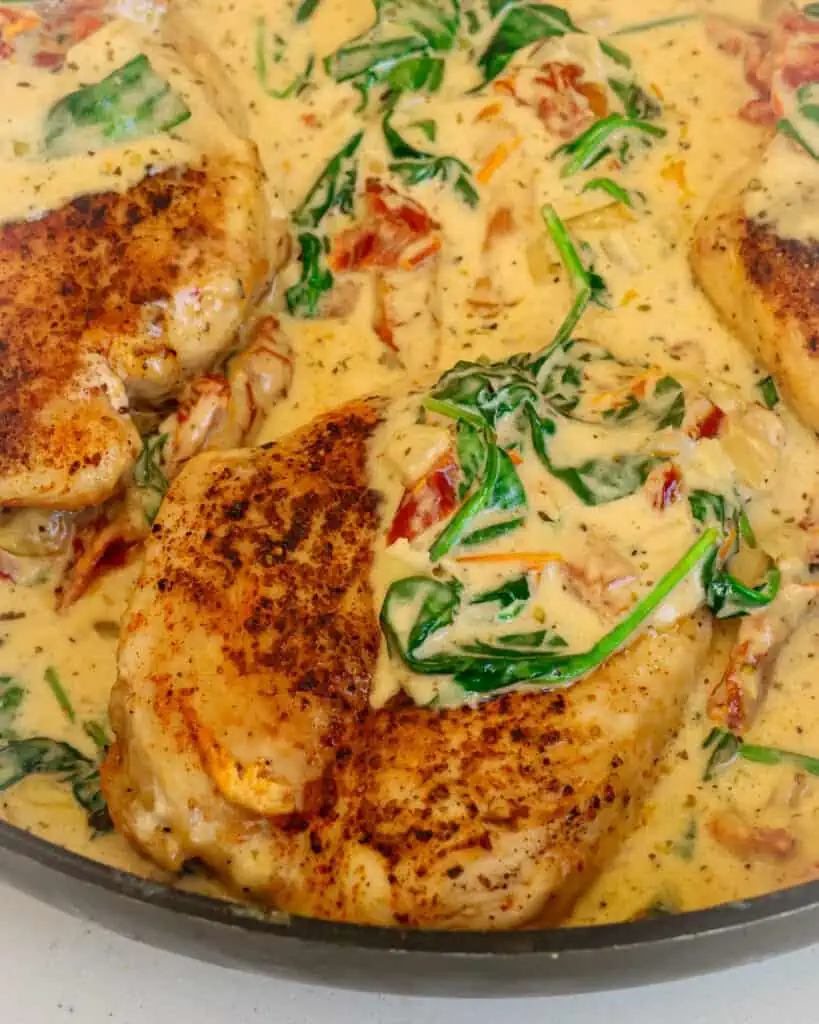 A delectable, easy one-skillet chicken breast recipe with sun-dried tomatoes and spinach in a creamy Parmesan sauce with Italian seasoning.