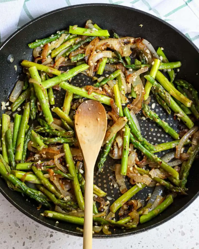 Add the asparagus and cook for 2-3 minutes or until crisp tender.  Now reduce the heat to low and add the garlic cooking for 1 minute while stirring 