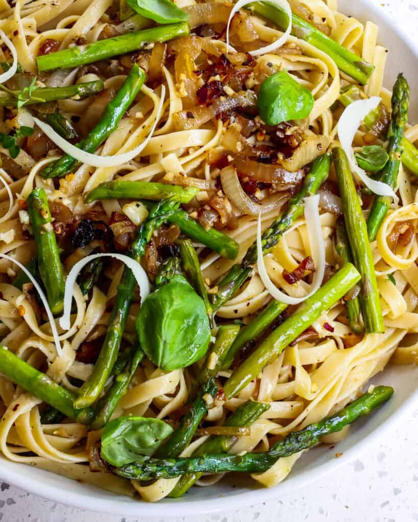 This quick and easy Asparagus Pasta is sautéed onions, fresh asparagus, sweet garlic, and fettuccine tossed with olive oil, Parmesan cheese, red pepper flakes, fresh herbs and lemon zest. 