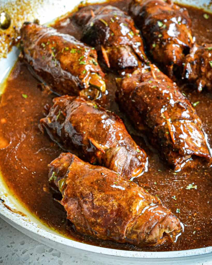German Beef Rouladen in a skillet with the gravy.