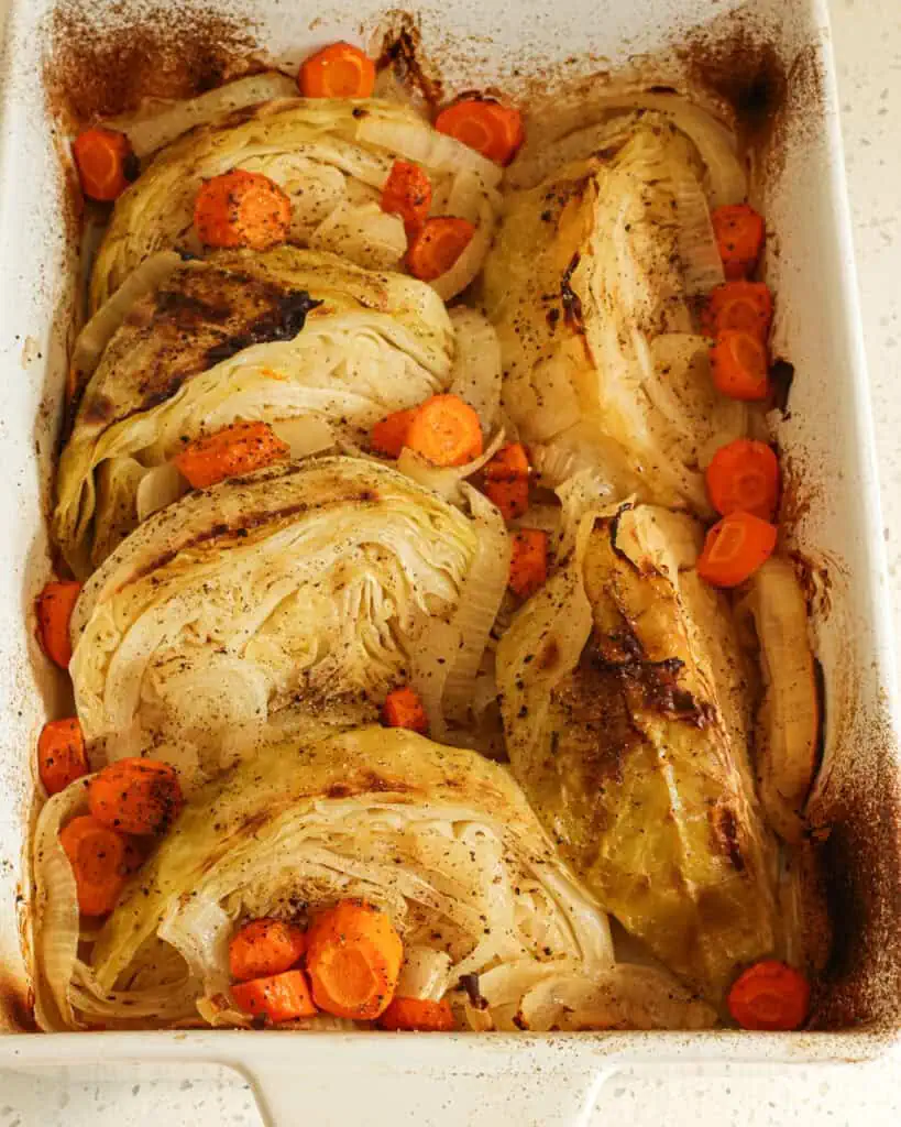 A 9x13 inch white casserole dish filled with braised cabbage.