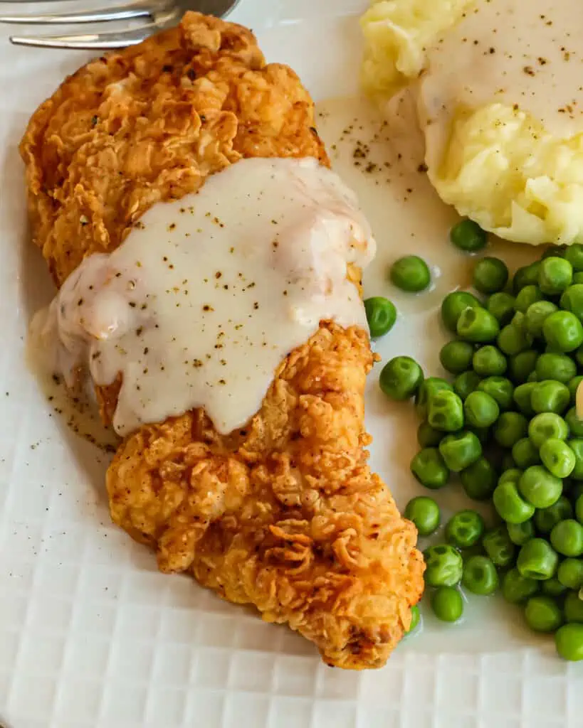 Chicken Fried Chicken is crispy breaded boneless skinless chicken breasts fried to golden perfection and served slathered with country white gravy seasoned with lots of fresh ground black pepper. 