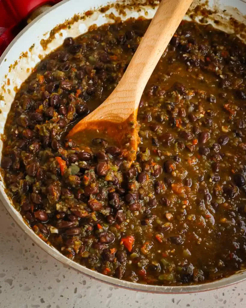 Stir in the black beans, ground cumin, dried oregano, and vinegar. Simmer for 20-25 minutes or until desired consistency. Season with salt and pepper to taste.